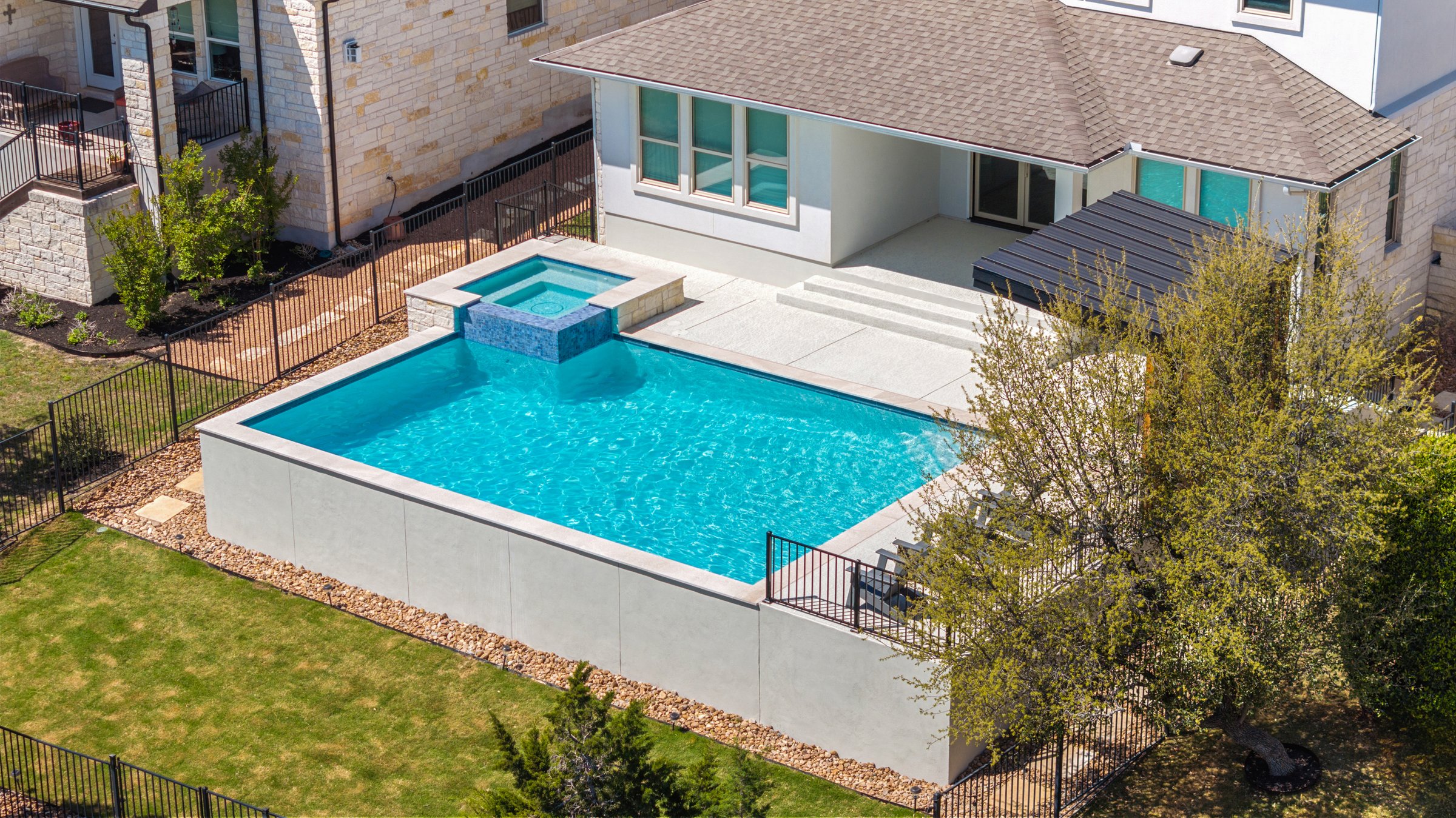 Wide aerial view of Azure Terrace modern backyard pool and outdoor kitchen in Austin TX