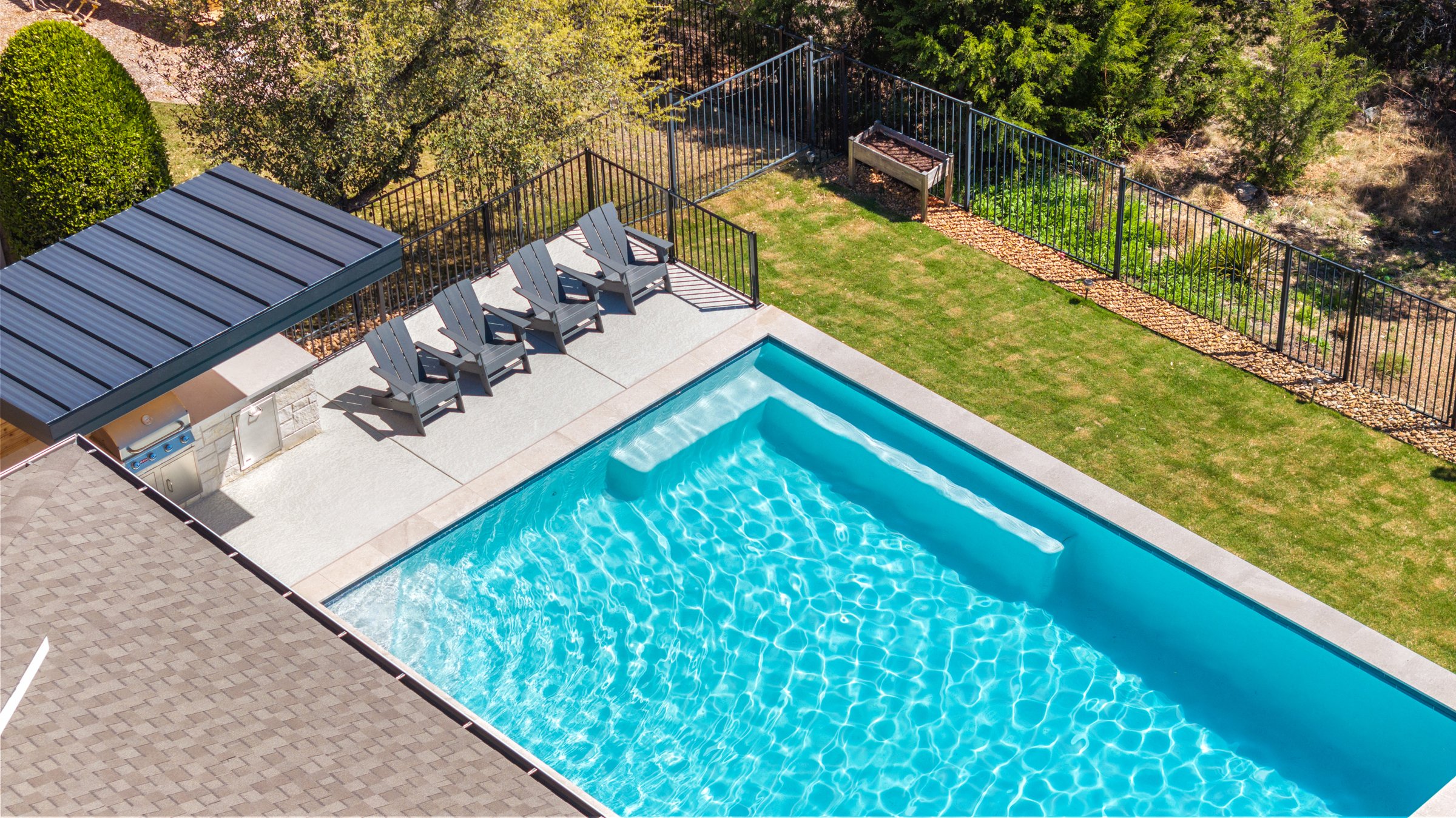 Aerial view of Azure Terrace modern pool with tanning ledge and lounge chairs by Wild Basin Pools Austin TX