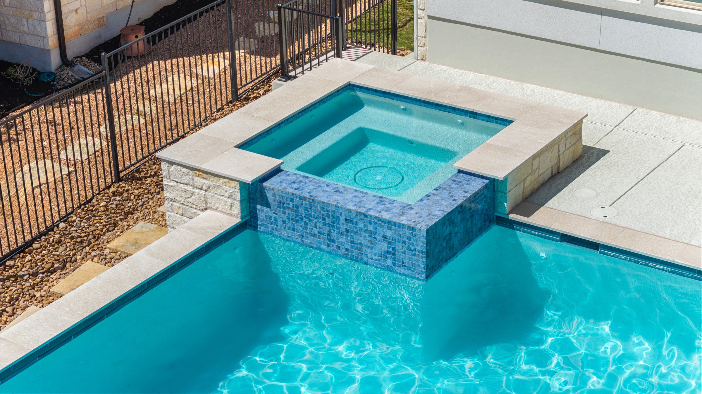 Aerial detail of Azure Terrace raised spa with blue mosaic tile spillover by Wild Basin Pools Austin TX