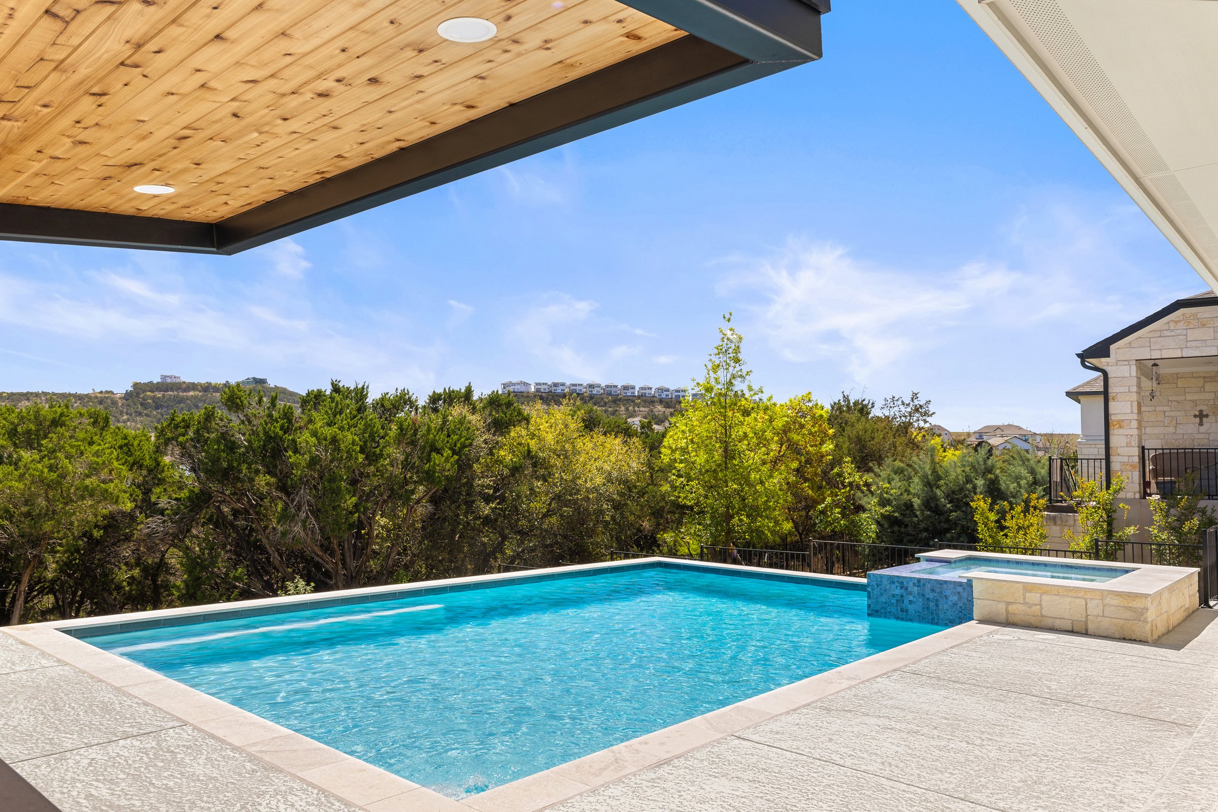 Azure Terrace pool and Hill Country views framed through cedar wood pergola ceiling in Austin TX