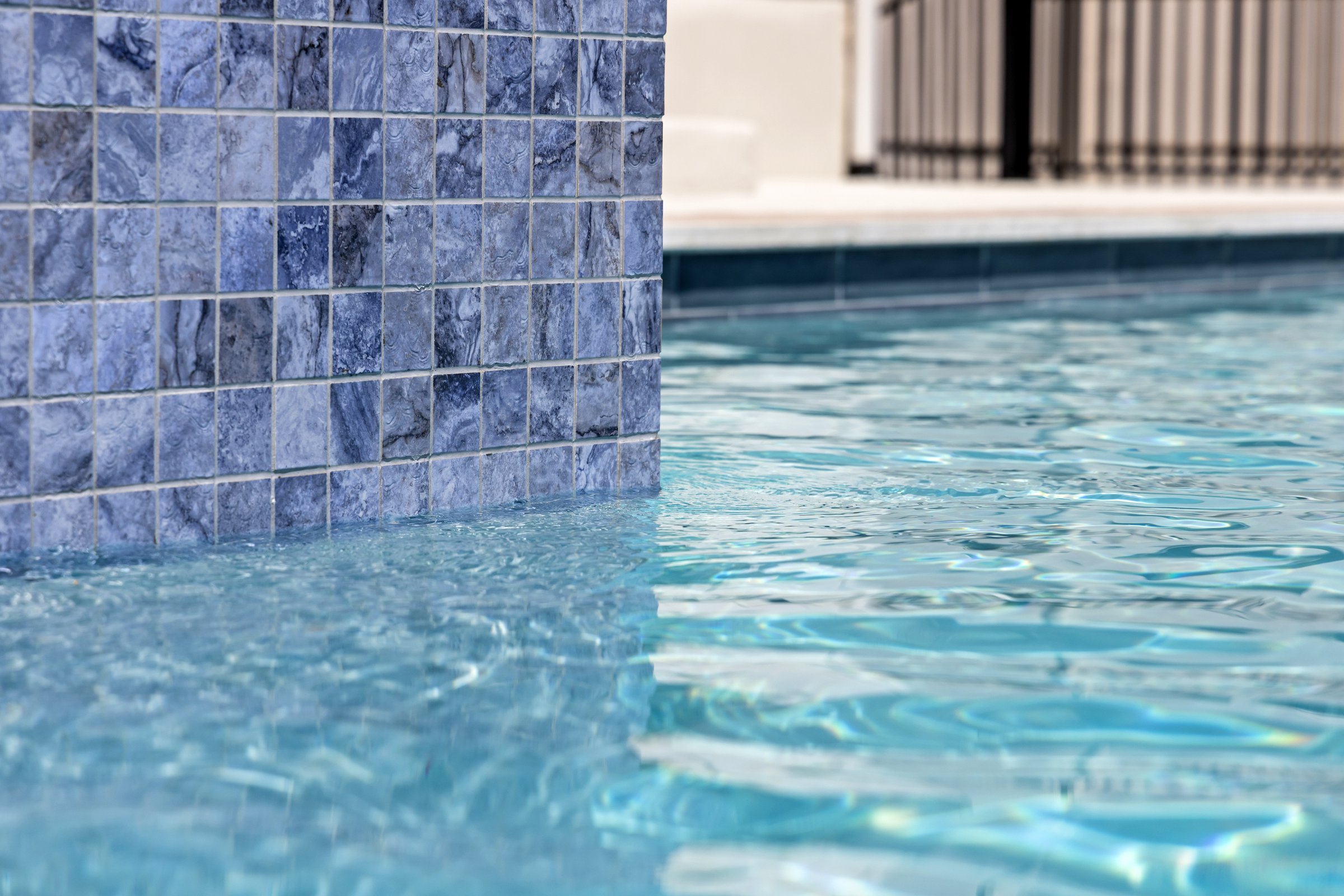 Azure Terrace pool at water level with blue mosaic tile reflection by Wild Basin Pools Austin TX