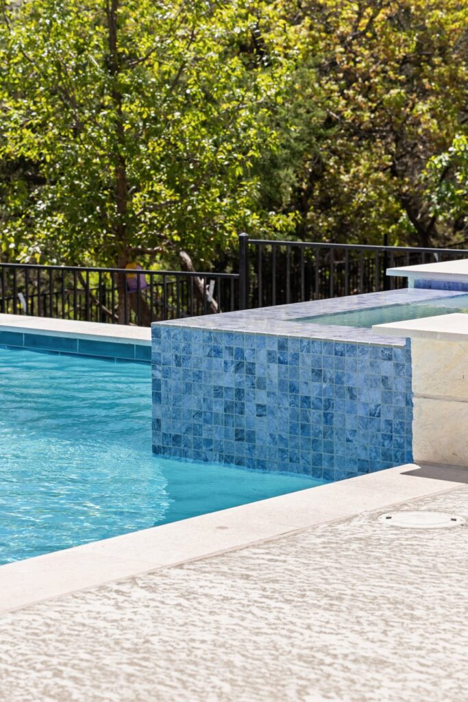Raised spa with blue mosaic tile spillover at Azure Terrace modern pool by Wild Basin Pools Austin TX