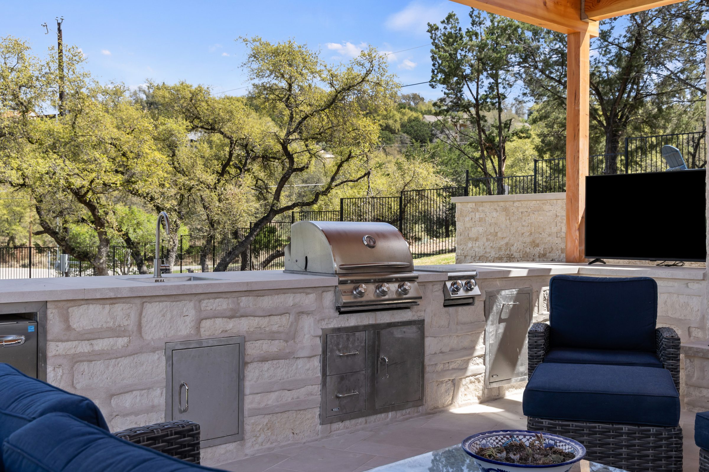 Built-in stainless steel grill and sink detail at The Commons outdoor kitchen under the cedar pavilion by Wild Basin Pools Austin TX