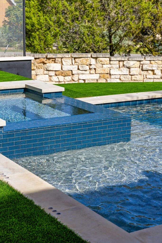 Blue tile spa with Hill Country stone wall – The Axis Wild Basin Pools Austin TX