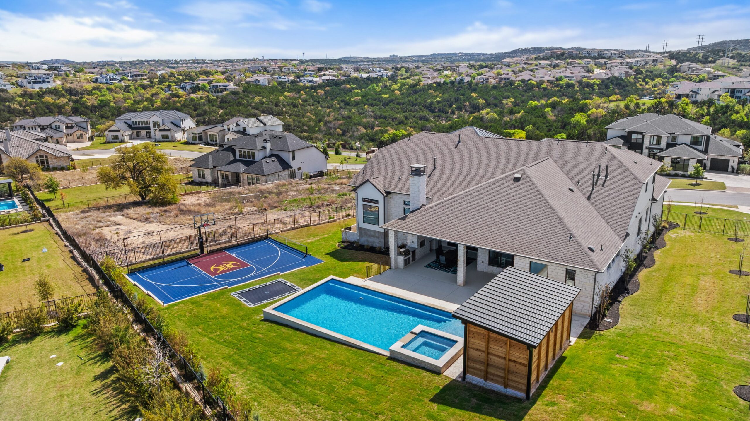 Aerial view of The Backyard Club pool and full estate with Hill Country neighborhood views by Wild Basin Pools Austin TX
