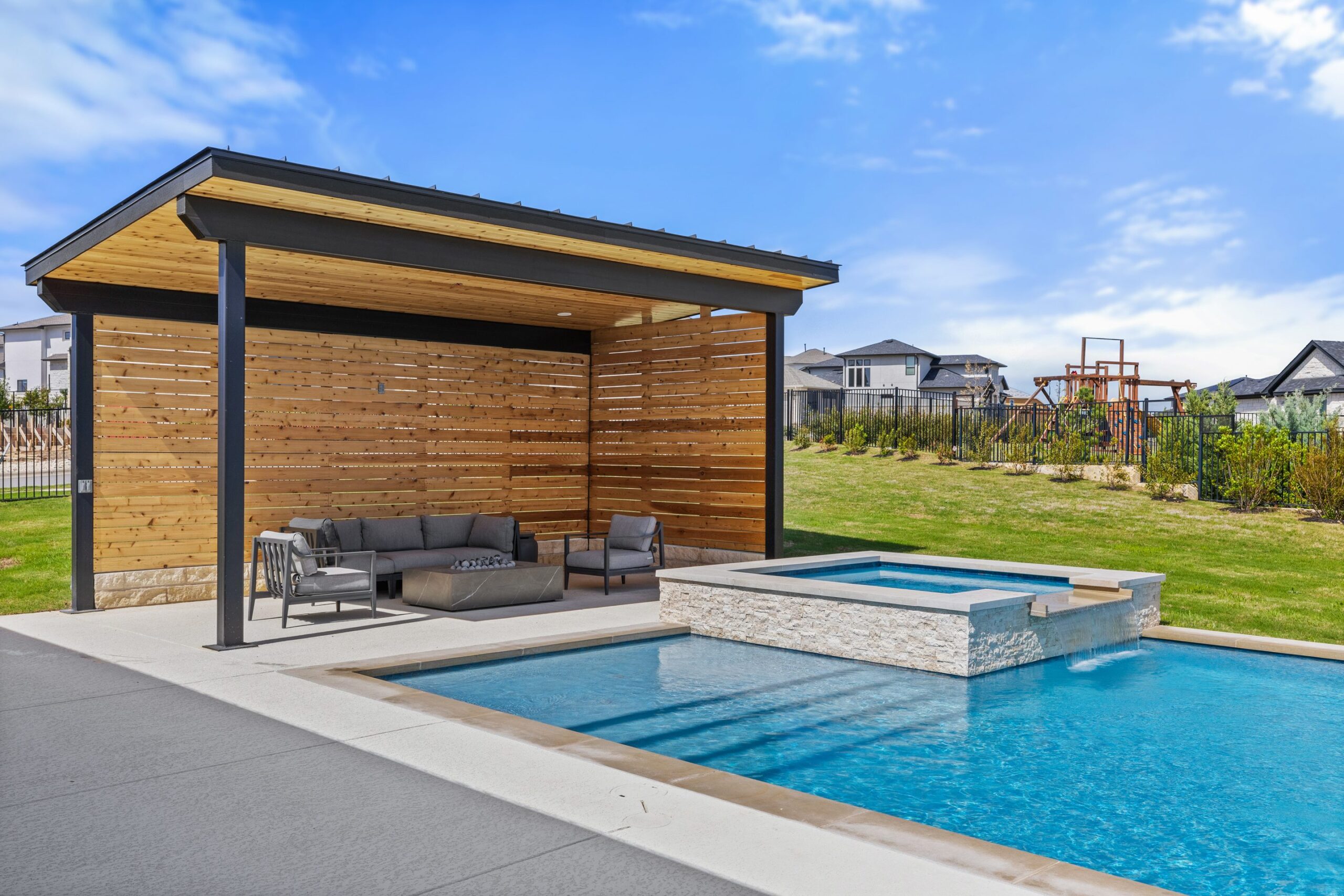 Geometric pool with raised spa and travertine stone coping at The Backyard Club by Wild Basin Pools Austin TX